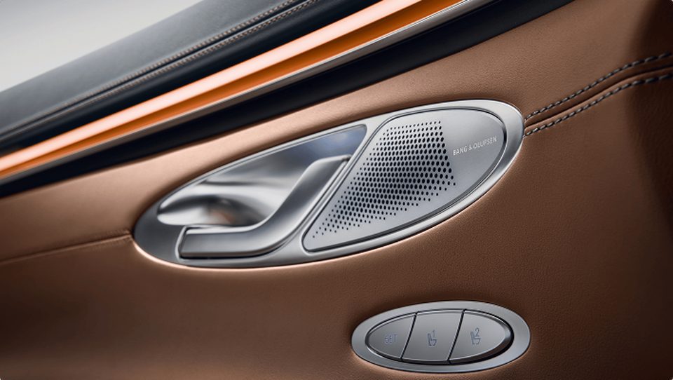 Close-up of the metallic Bang & Olufsen speaker grille beside a door handle.
